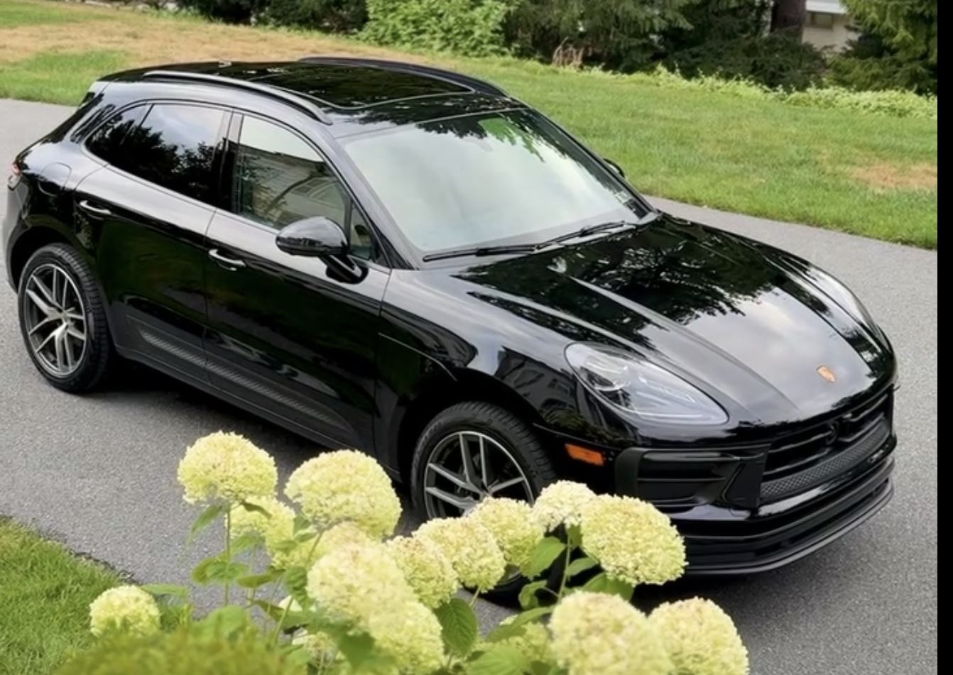 Detailed black Porsche Macan, exterior finish, parked on a driveway