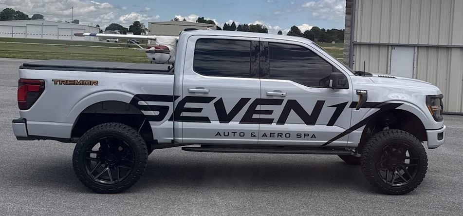 Seven17 service truck, full side profile, parked near a hangar