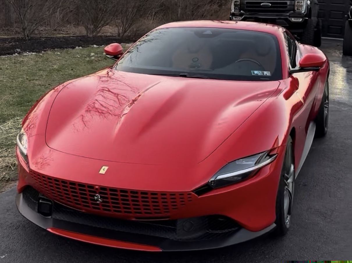 Detailed red Ferrari, front three-quarter view, Seven17 truck behind